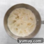 Cream cheese frosting in a mixing bowl, showcasing its smooth and fluffy texture.