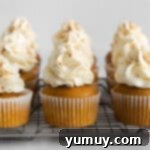 Frosted pumpkin pie cupcakes arranged on a cooling rack, showcasing the final delicious presentation.