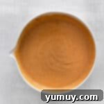 Cupcake batter being mixed in a large bowl, showing a smooth, consistent texture.