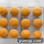 Unfrosted pumpkin pie cupcakes arranged neatly on a wire cooling rack.