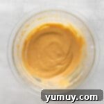 Creamy pumpkin pie filling being mixed to a light and fluffy consistency in a bowl.