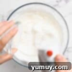 Golden Butterscotch Delight 12 Granulated sugar being slowly streamed into whipping egg whites for meringue.