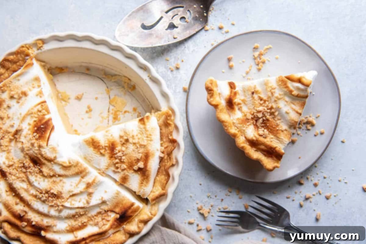 Golden Butterscotch Delight 24 A mouth-watering slice of butterscotch meringue pie on a plate, next to the whole golden-topped pie, inviting enjoyment.