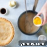 Golden Butterscotch Delight 6 Adding beaten egg yolks to the warm butterscotch mixture in the saucepan.