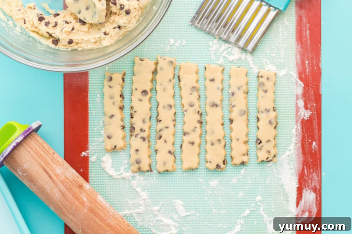 Golden Cookie Fries with Chocolate Chips 15 Raw cookie dough strips, cut into fry shapes with a crinkle cutter, on a silicone mat.