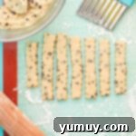 Golden Cookie Fries with Chocolate Chips 8 Raw cookie dough strips, cut into fry shapes with a crinkle cutter, on a silicone mat.