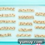 Golden Cookie Fries with Chocolate Chips 9 Unbaked Chocolate Chip Cookie Fries arranged on a parchment-lined baking sheet, ready for chilling.