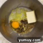 Decadent Chocolate Zucchini Cupcakes 7 wet ingredients for zucchini cupcakes in a stainless mixing bowl.