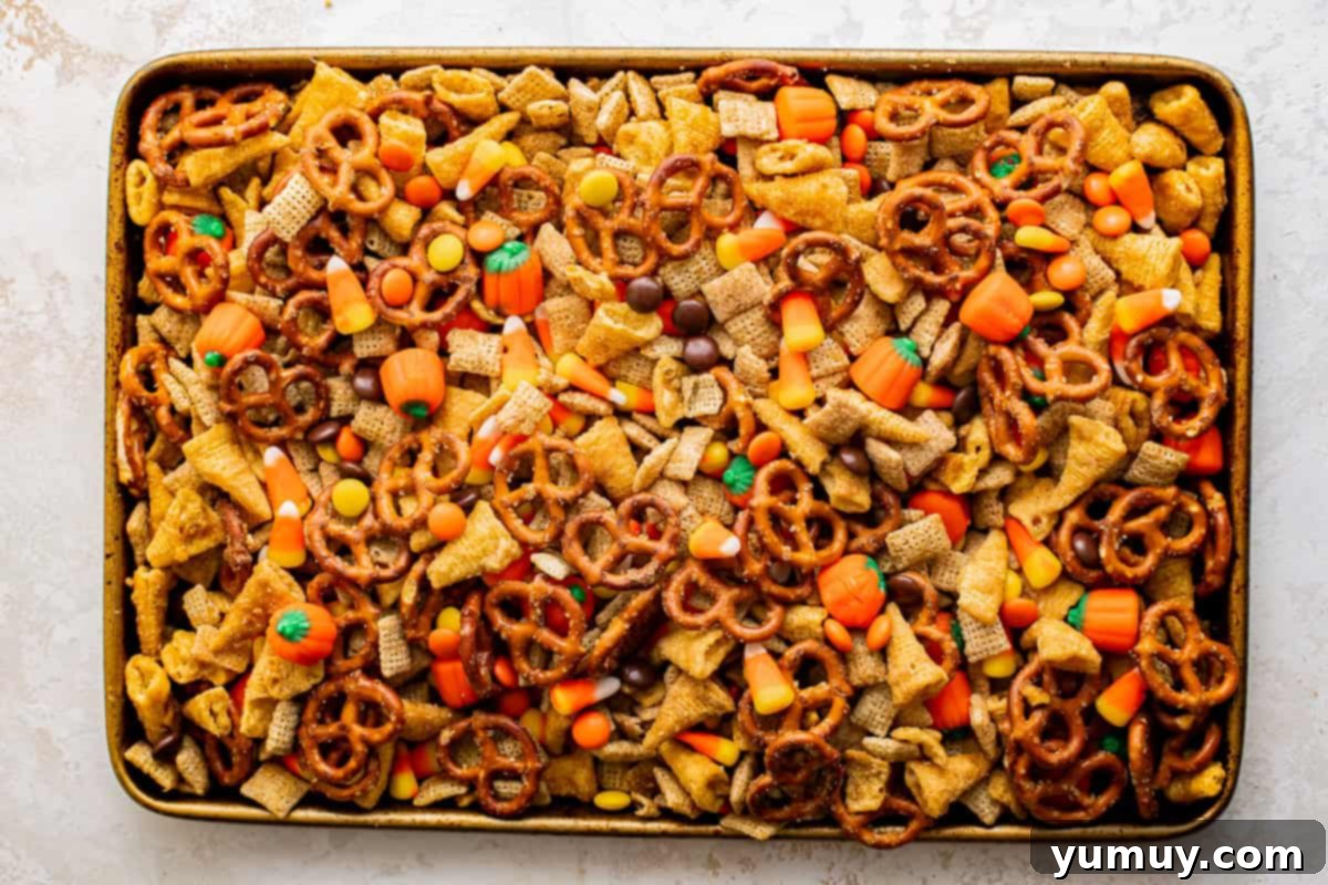 A tray full of halloween snack mix filled with pretzels and candy.