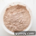 overhead view of homemade hot chocolate mix in a white bowl, freshly whisked.
