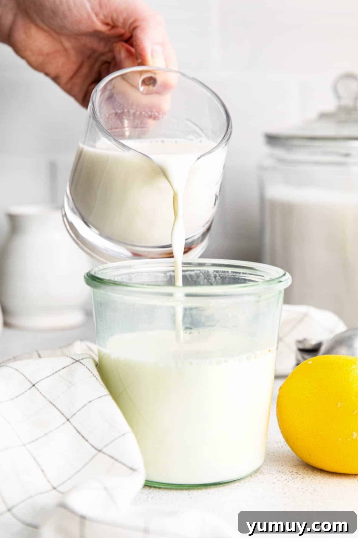 Crafting Your Own Buttermilk 2 pouring homemade buttermilk into a glass jar.