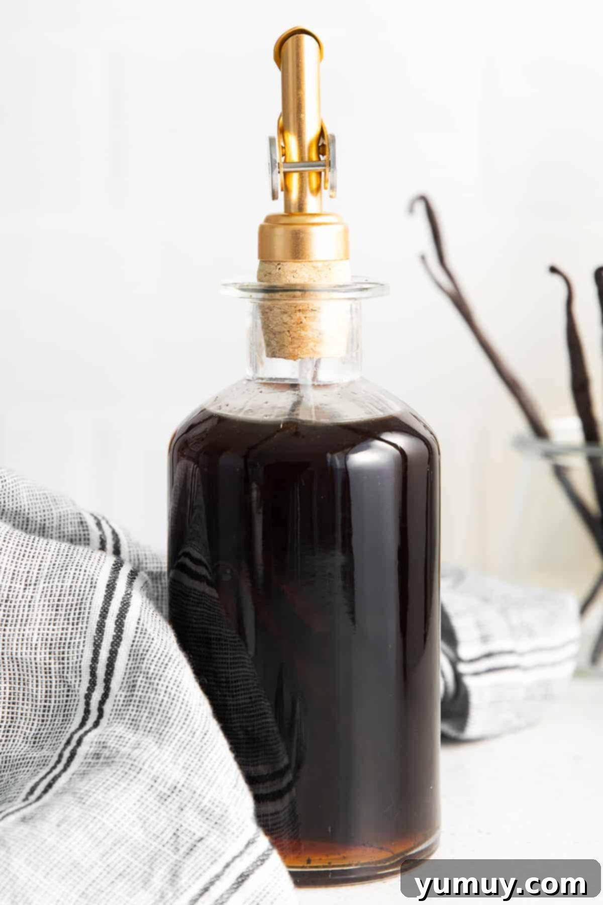 Homemade vanilla extract infusing in a glass container