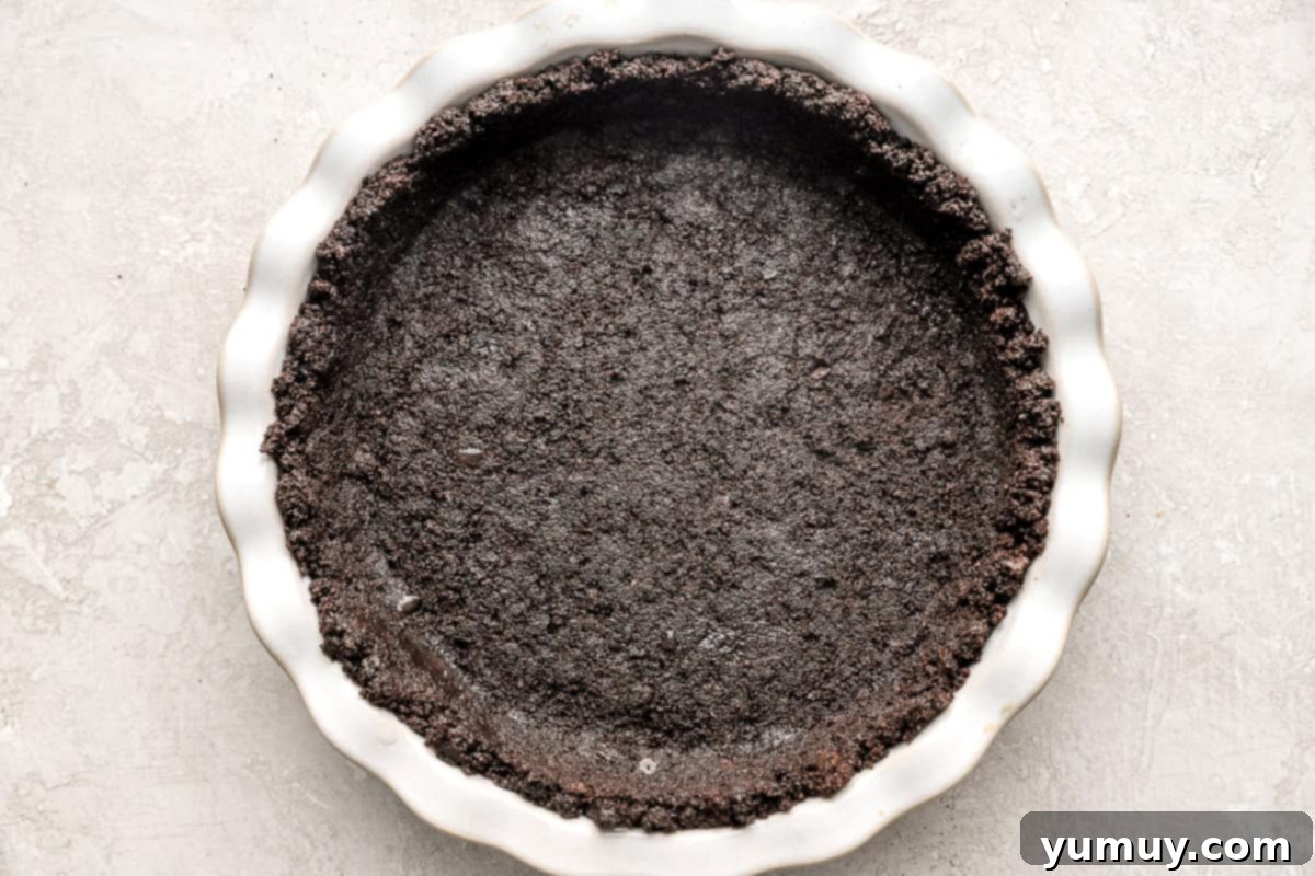 Oreo pie crust pressed into a pie dish.