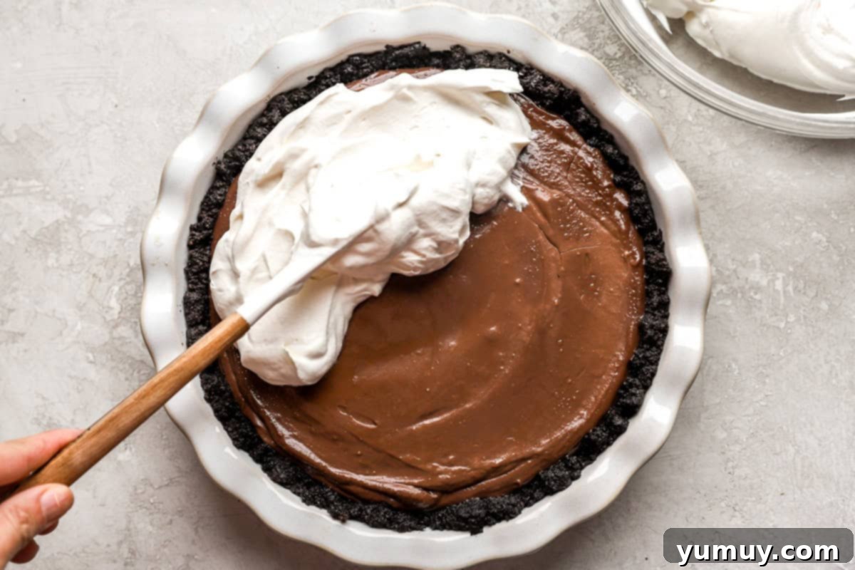 Spreading whipped topping onto a pie.