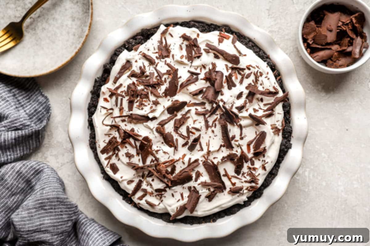 A whole chocolate cream pie finished with whipped topping and chocolate shavings.