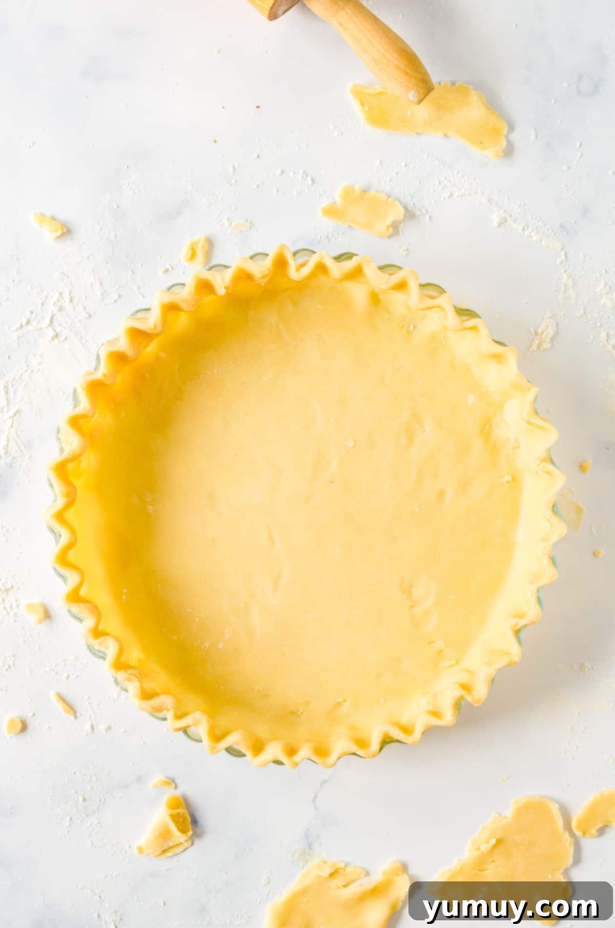 food processor pie crust dough pressed and crimped into a glass pie pan.