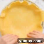 Pressing pie crust into a pie plate.
