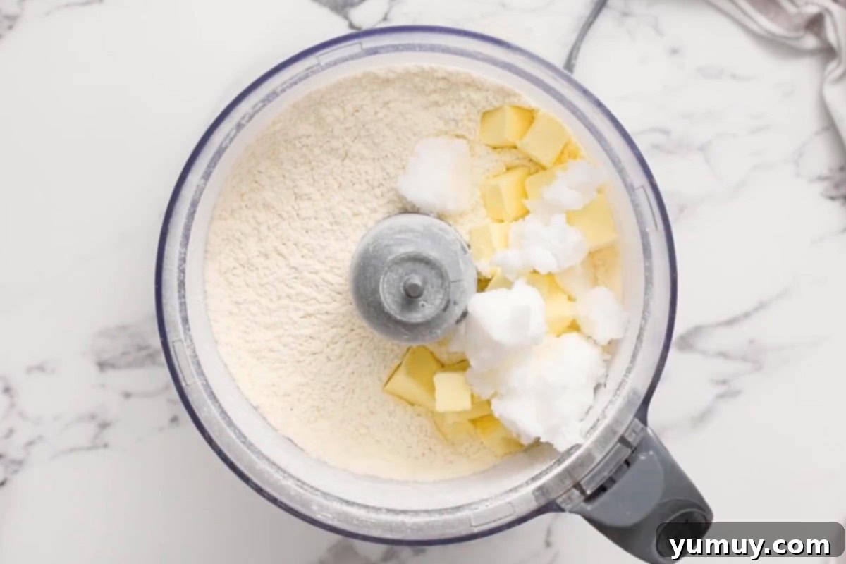 Cubes of butter and shortening added to dry ingredients in a food processor.