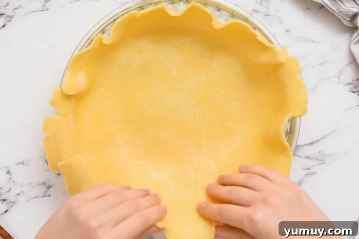 Pressing pie crust into a pie plate.