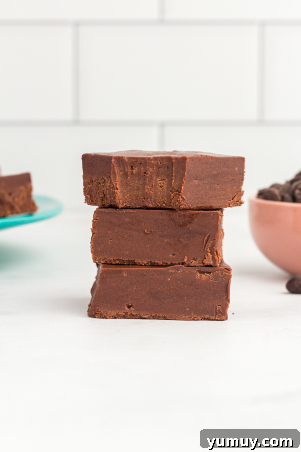 Dreamy Marshmallow Fudge 2 a bitten piece of fantasy fudge stacked on 2 other pieces of marshmallow fluff fudge.