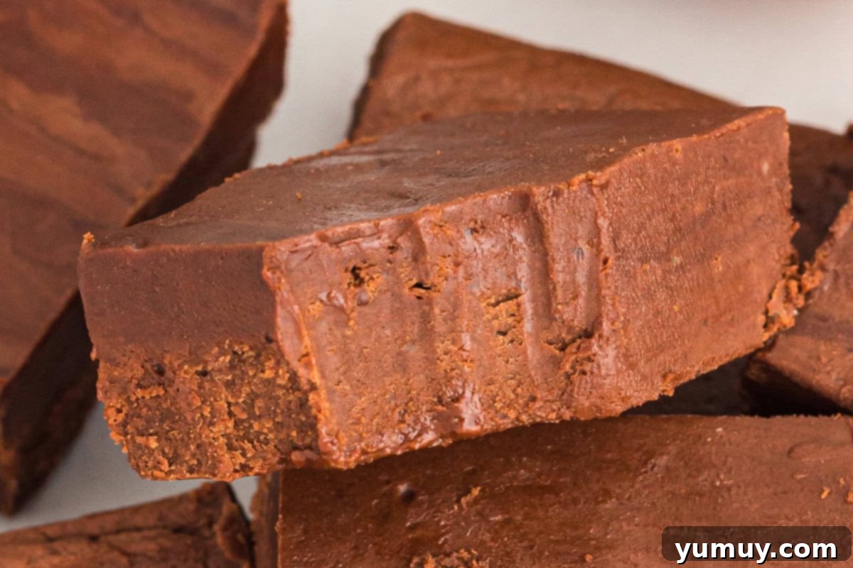 Dreamy Marshmallow Fudge 3 a bitten piece of marshmallow fluff fudge resting on more fudge.