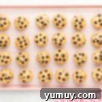 24 brownie stuffed chocolate chip cookies lined on a baking tray