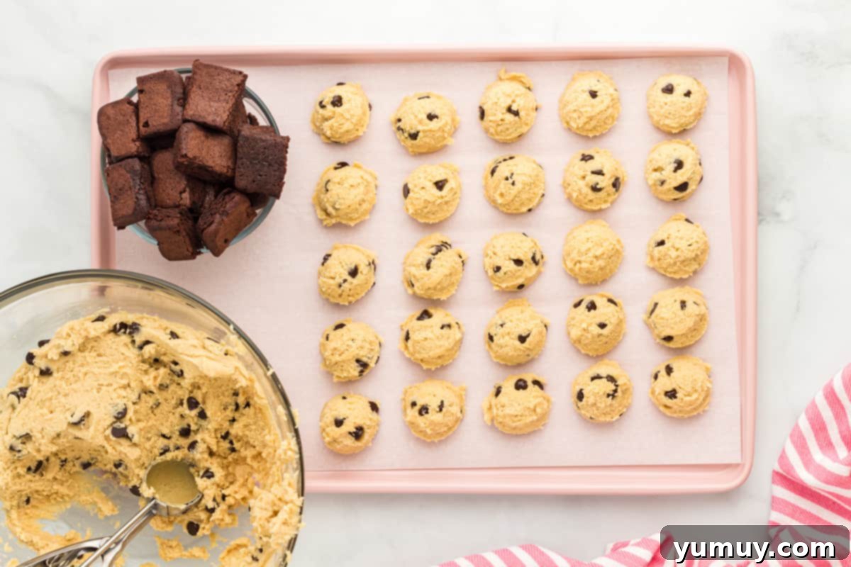 chocolate chip cooke dough balls and cubes of brownies arranged on a baking tray