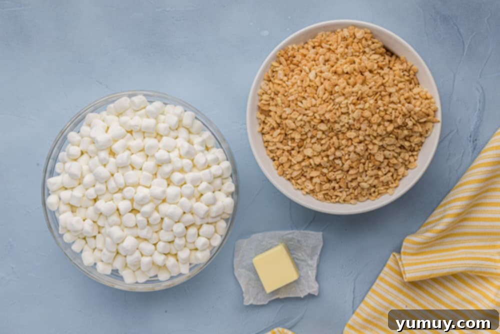 Crispy Marshmallow Squares 5 Graham crackers, marshmallows, and butter ready on a blue background.