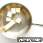 The Secret to Golden Brown Butter 5 partially cubed butter in a frying pan.