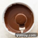 dipping an Oreo into melted chocolate using a fork