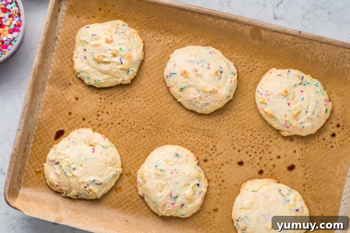 Cake Batter Confetti Cookies 14 Freshly baked and slightly cooled confetti cake cookies resting on a wire rack.