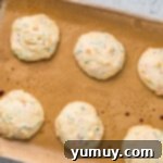 Cake Batter Confetti Cookies 8 Freshly baked cookies cooling on a wire rack after being removed from the oven.