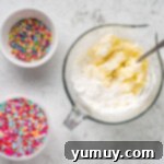 Cake Batter Confetti Cookies 9 Ingredients for the frosting, including powdered sugar, butter, and cream cheese, laid out in bowls.