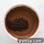 mixing chocolate chips into muffin batter with a spatula.