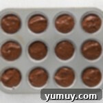 muffin tin filled with chocolate batter, ready for baking.