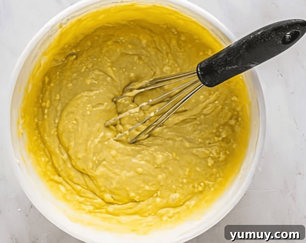 Sun-Kissed Lemon Blackberry Symphony 11 yellow cake batter in a bowl with a whisk.