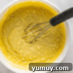 Sun-Kissed Lemon Blackberry Symphony 5 yellow cake batter in a bowl with a whisk.