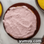 Sun-Kissed Lemon Blackberry Symphony 9 overhead view of a cake coated in blackberry frosting on a cake stand.