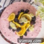 Sun-Kissed Lemon Blackberry Symphony 10 overhead view of a blackberry lemon cake topped with lemons and blackberries.