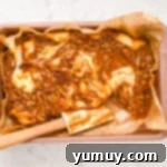 A pan of fudge with a spoon, showing the marbling technique as pralines are swirled into the white chocolate.