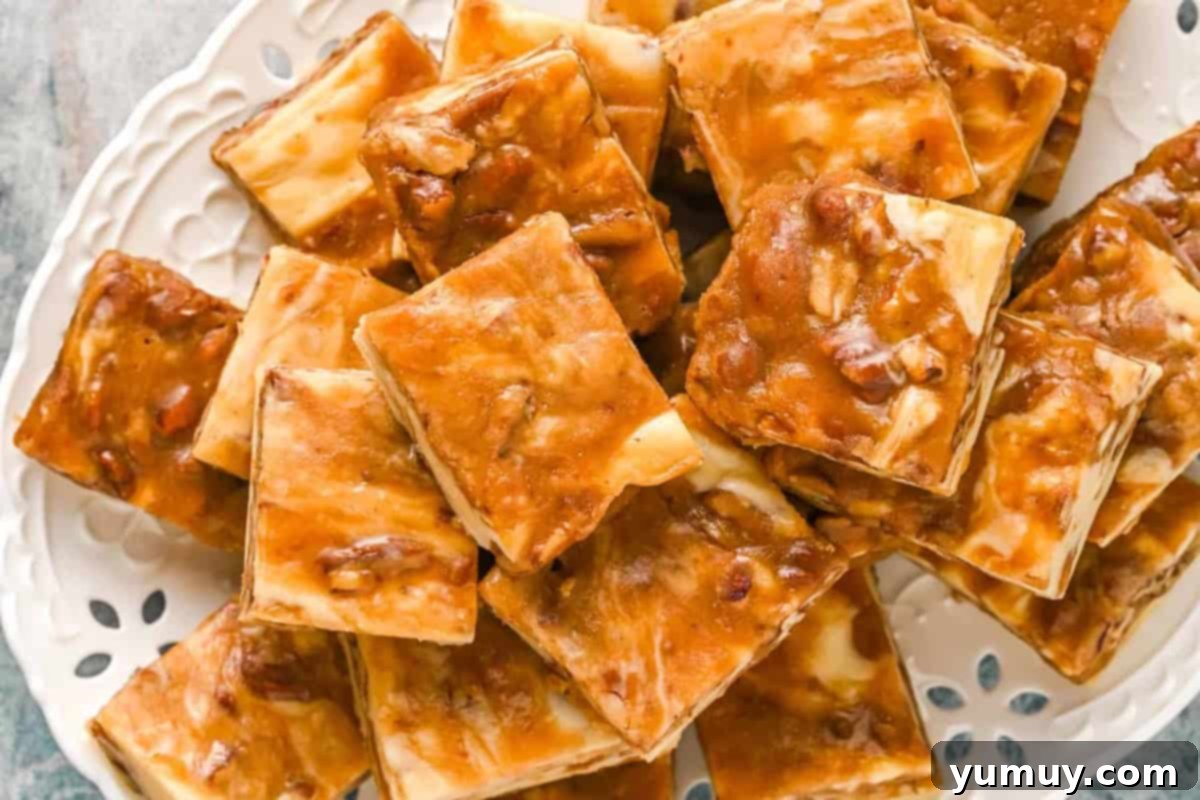 Overhead view of pieces of pralines and cream fudge haphazardly stacked on an oval serving platter, highlighting the beautiful swirl.
