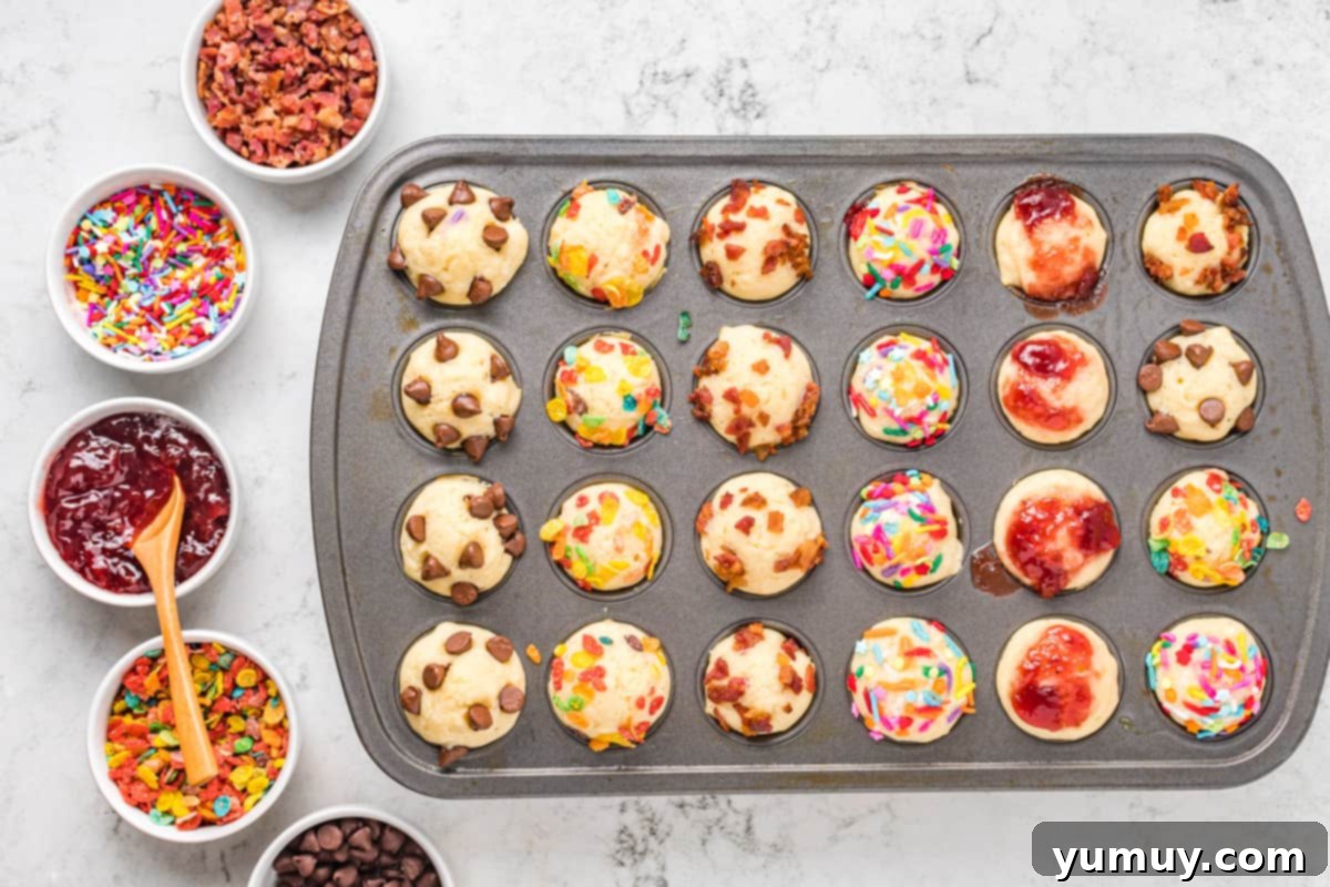 A tray of freshly baked mini pancake muffins cooling, with toppings visible on their surfaces.