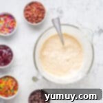 Pancake batter being mixed in a large bowl, showing a smooth, thick consistency.