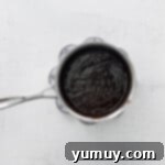 Smooth, melted chocolate and coffee mixture in a saucepan, ready for the cheesecake.