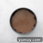 Smooth chocolate cheesecake batter poured over the Oreo crust in a round springform pan.