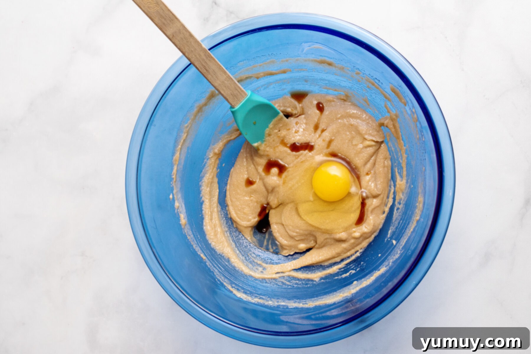 Golden Brown Sugar Delights 6 A bowl showing wet ingredients (melted butter, brown sugar, egg, vanilla) being mixed with a spatula.