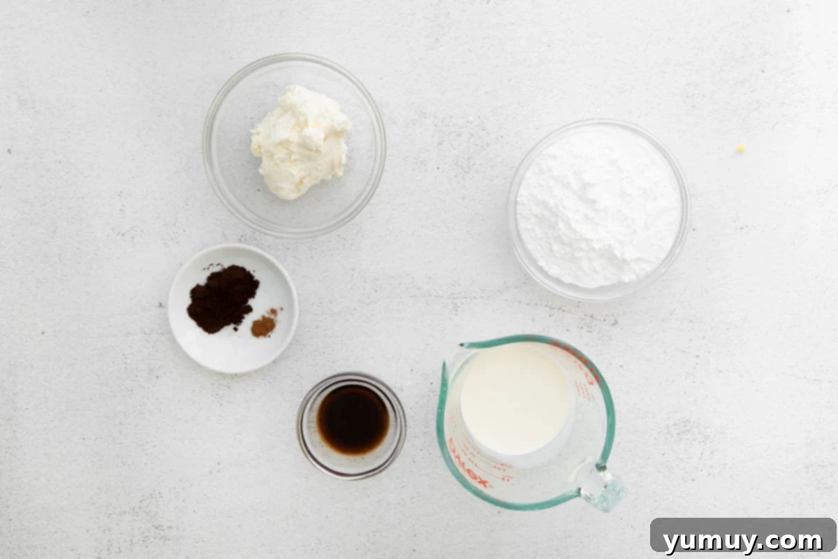 Individual bowls containing the super cold ingredients for the tiramisu frosting: heavy whipping cream, mascarpone cheese, Kahlúa coffee liqueur, powdered sugar, instant espresso powder, and cinnamon, ready for mixing.