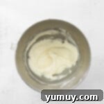 Decadent Tiramisu Cupcakes 9 mascarpone frosting in a stainless mixing bowl.