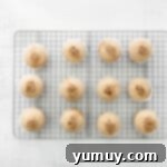 Decadent Tiramisu Cupcakes 10 coffee soak poured over 12 baked cupcakes on a cooling rack.