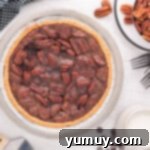 An overhead shot of a freshly baked chocolate pecan pie, glistening in its ceramic pie dish, just removed from the oven and ready to cool.